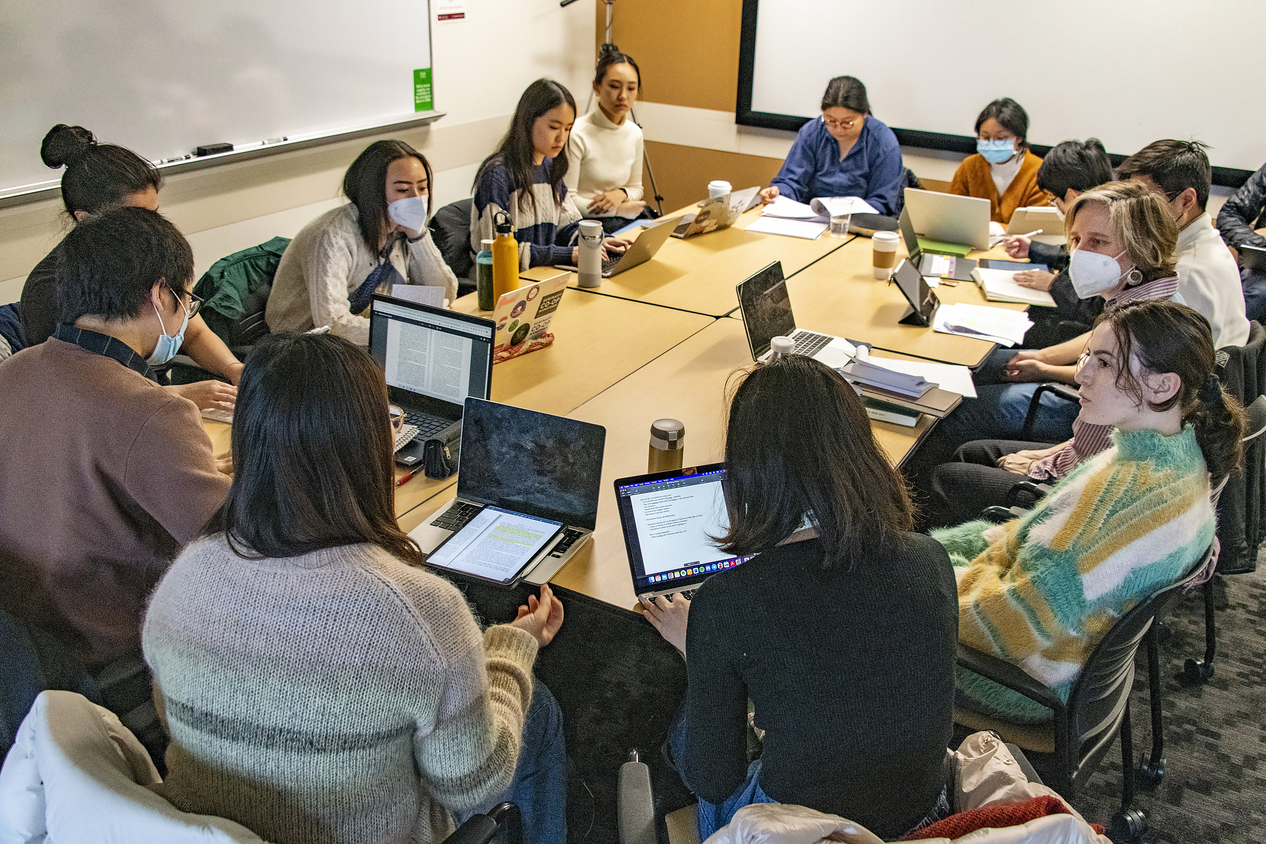 students sitting around a seminar table with computers and notes