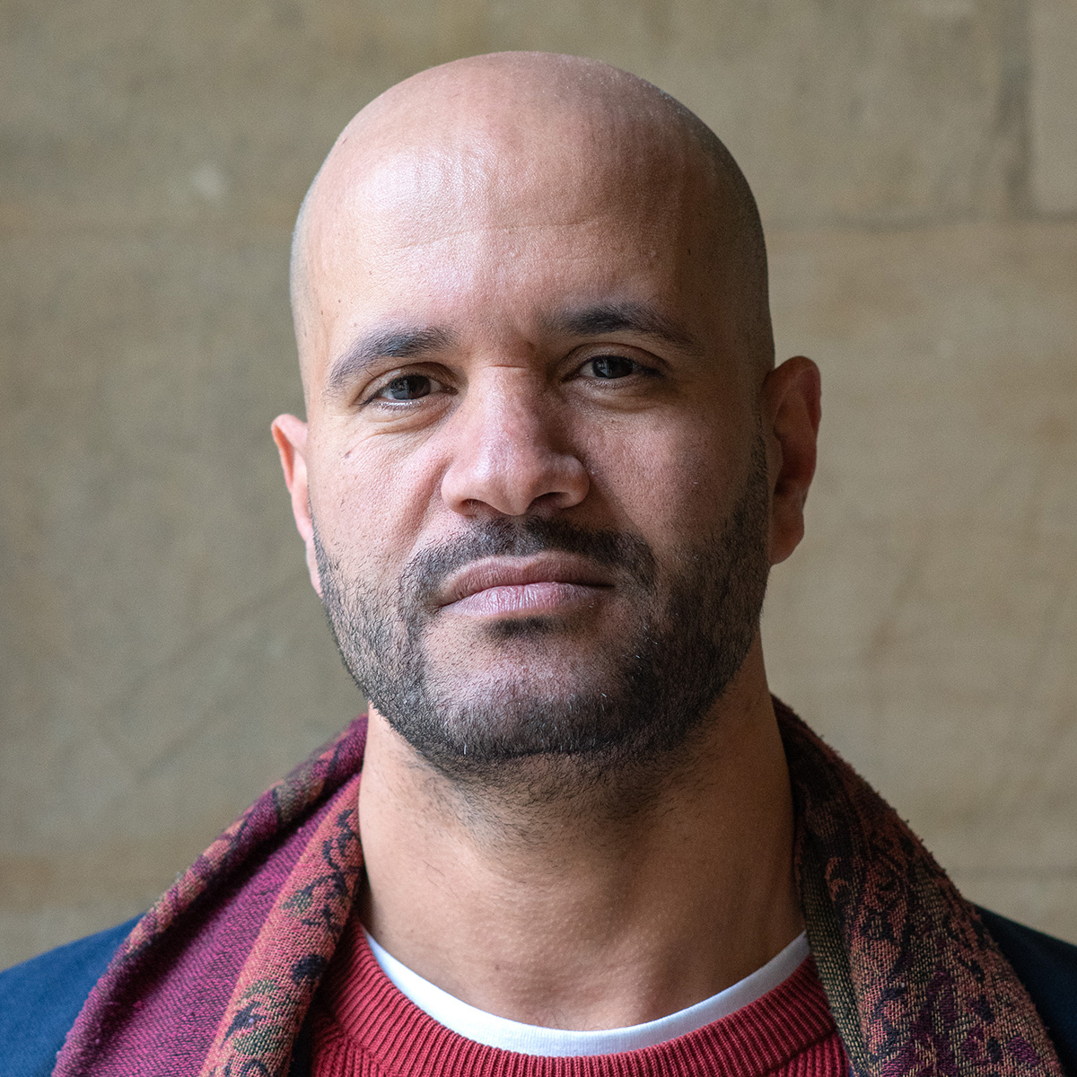 Man with blue jacket and maroon scarf.