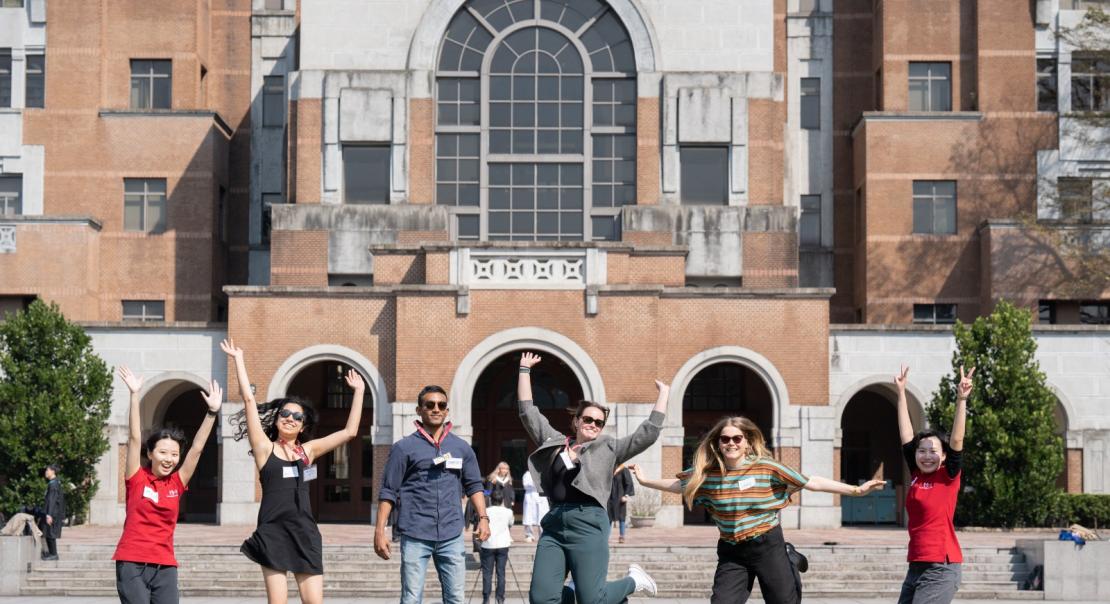 Students jumping in front of a building