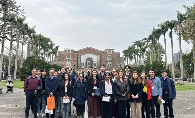 Students, instructors, and hosts pose for a group photo in front of National Taiwan University